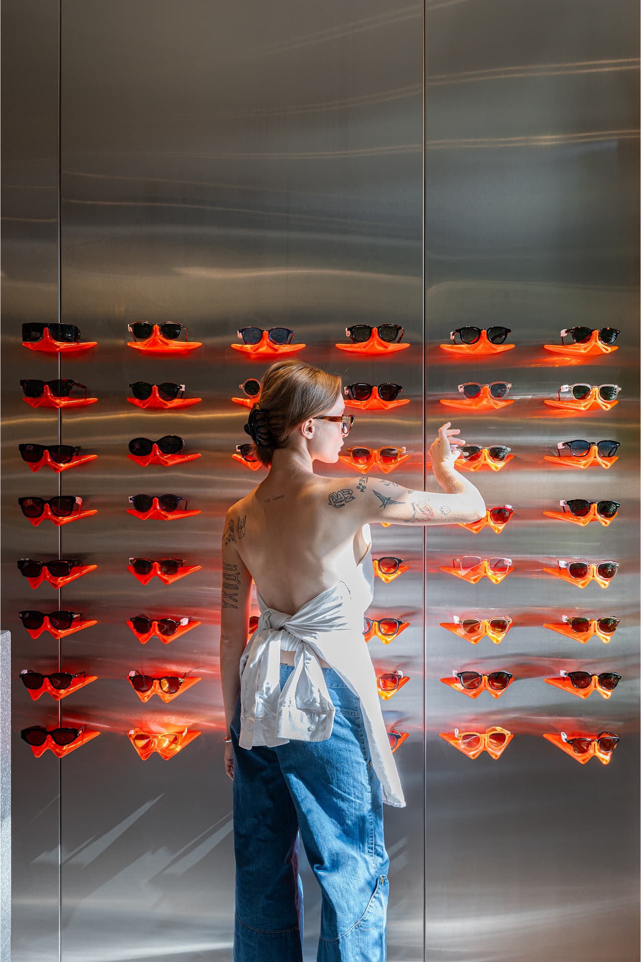 Orange 3D-printed holders on stainless steel wall