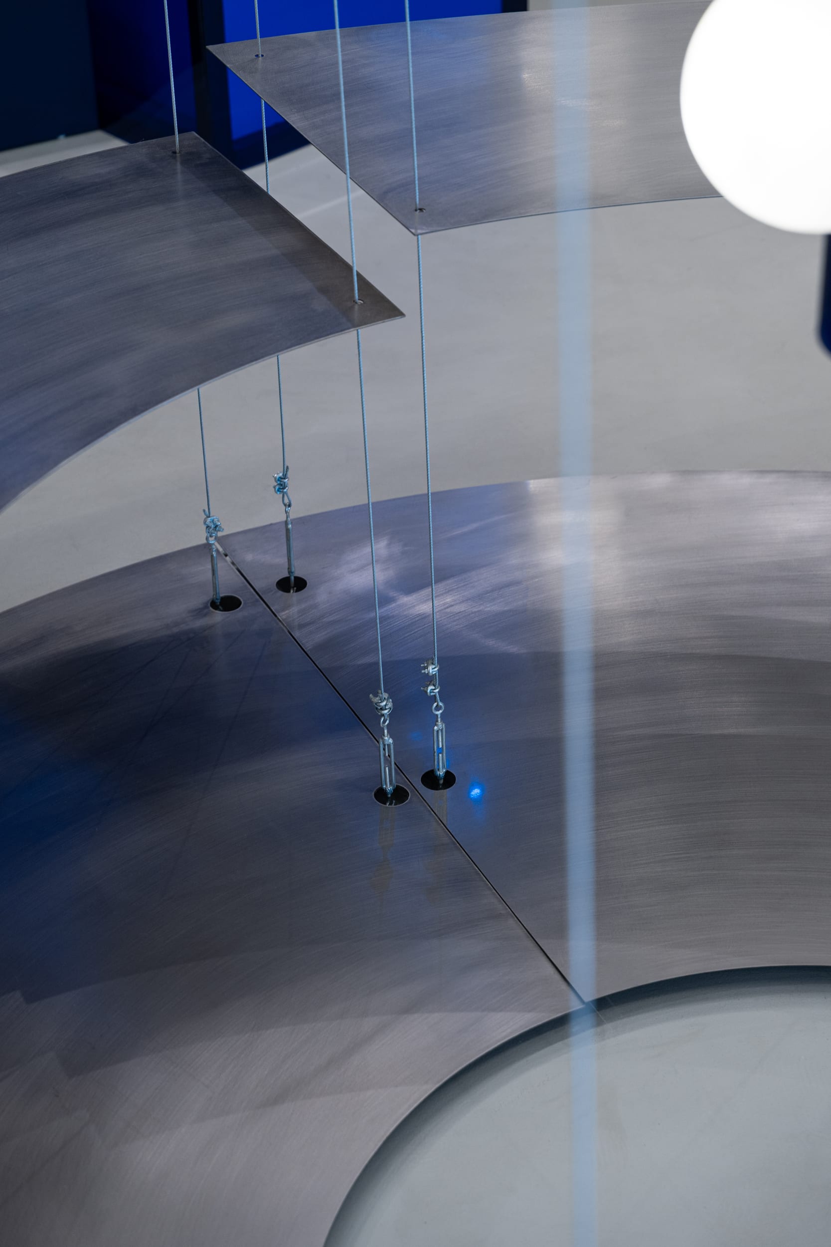Detail of the cable-suspended brushed-steel display panels